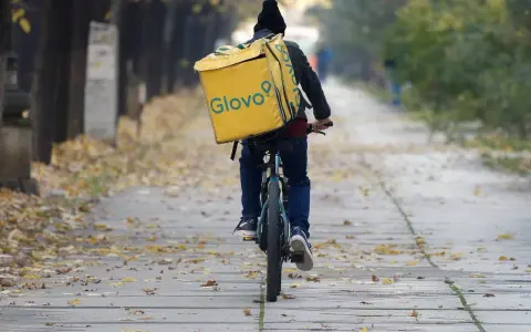 Kurier na rowerze z żółtą torbą Glovo jedzie ależsza. Chyba glovo nie działa, bo wygląda na zagubionego.