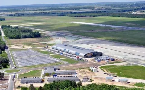 Nowoczesne wmi lotnisko z długim pasem startowym, przestronnym parkingiem i futurystycznym terminalem.