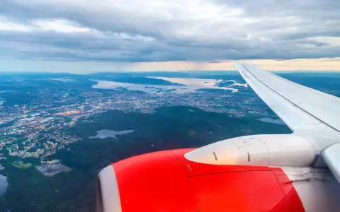 Widok z samolotu na Oslo i okoliczne fiordy, z widocznym skrzydłem i silnikiem.