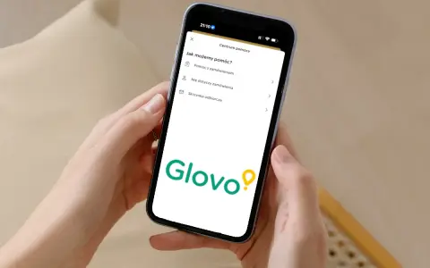 Na ekranie telefonu widoczny jest interfejs aplikacji Glovo z sekcją "Centrum pomocy". Tutaj znajdziesz informacje, jak uzyskać pomoc z zamówieniem, a także inne opcje.