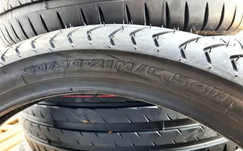 Zbliżenie na przekrój opony motocyklowej z widocznym rozmiarem 90/90-21M/C 54H.