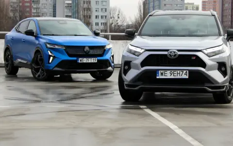 Niebieski i srebrny SUV, jedne z najlepszych aut, stoją na mokrym parkingu.