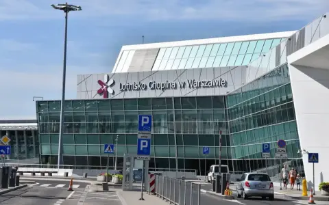 Nowoczesny budynek Lotniska Chopina w Warszawie. Droga prowadzi do terminalu, gdzie zaczyna się podróż z Warszawy Centralnej do lotniska Chopina.