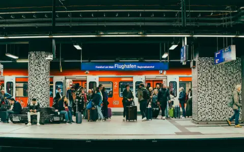 Pasażerowie z bagażami czekają na pociąg na peronie lotniska Frankfurt am Main Flughafen Regionalbahnhof.