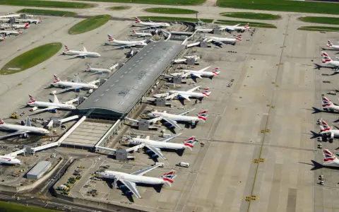 Lotnisko Heathrow tętni życiem, z wieloma samolotami British Airways czekającymi na pasażerów.