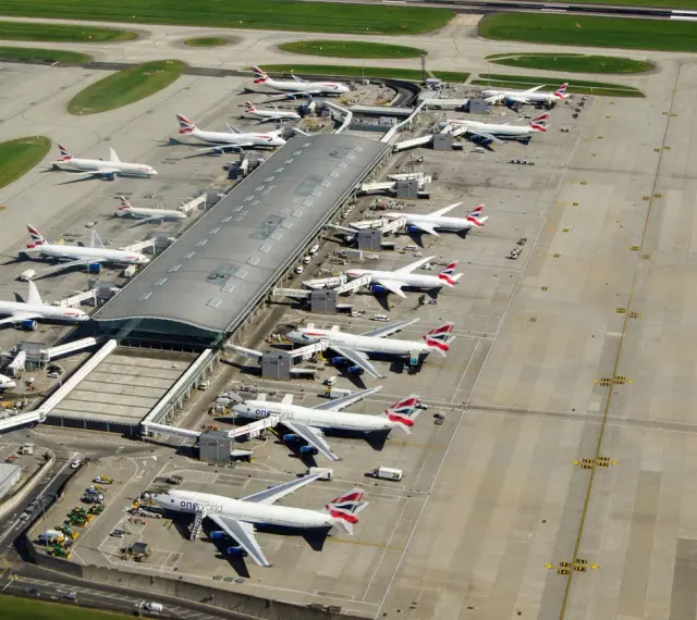 Lotnisko Heathrow tętni życiem, z wieloma samolotami British Airways czekającymi na pasażerów.