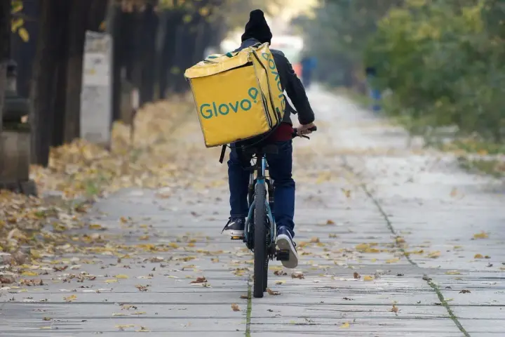 Kurier na rowerze z żółtą torbą Glovo jedzie ależsza. Chyba glovo nie działa, bo wygląda na zagubionego.