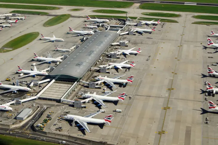 Lotnisko Heathrow tętni życiem, z wieloma samolotami British Airways czekającymi na pasażerów.
