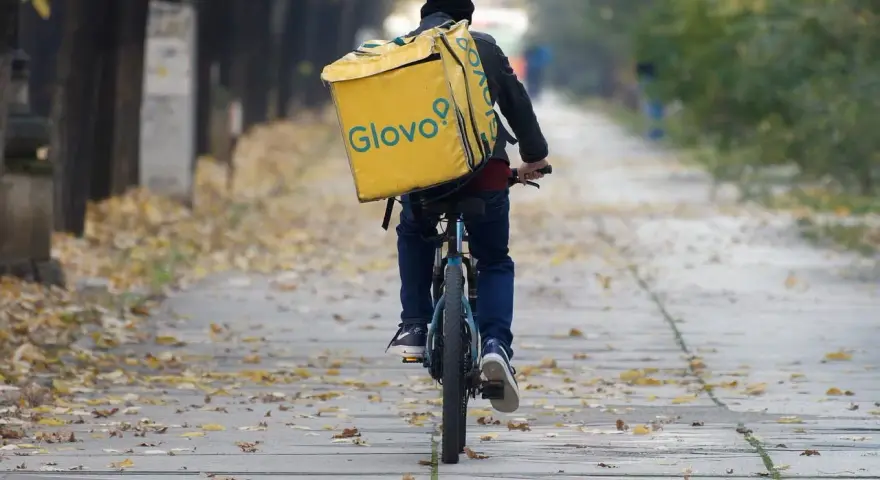Kurier na rowerze z żółtą torbą Glovo jedzie ależsza. Chyba glovo nie działa, bo wygląda na zagubionego.