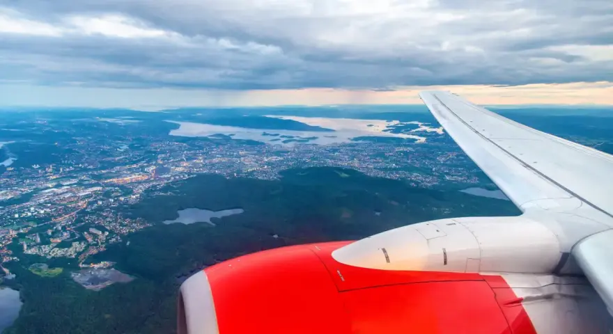 Widok z samolotu na Oslo i okoliczne fiordy, z widocznym skrzydłem i silnikiem.