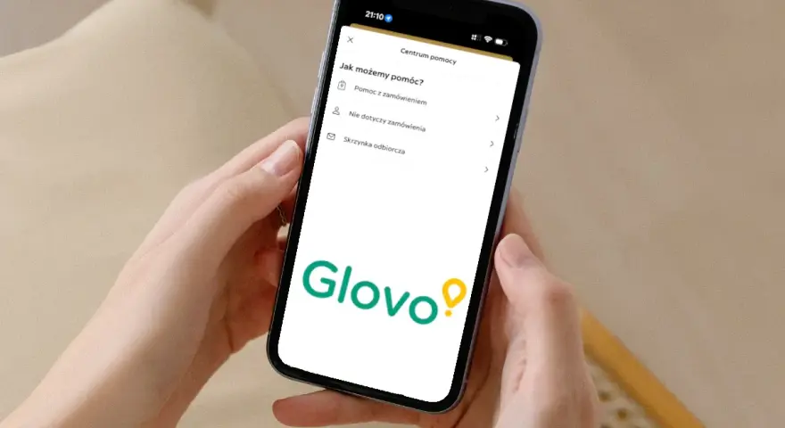 Na ekranie telefonu widoczny jest interfejs aplikacji Glovo z sekcją "Centrum pomocy". Tutaj znajdziesz informacje, jak uzyskać pomoc z zamówieniem, a także inne opcje.