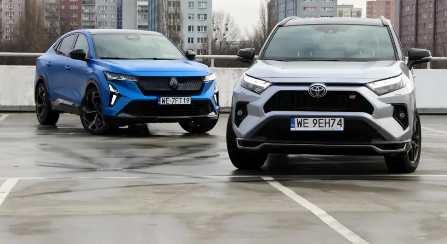 Niebieski i srebrny SUV, jedne z najlepszych aut, stoją na mokrym parkingu.