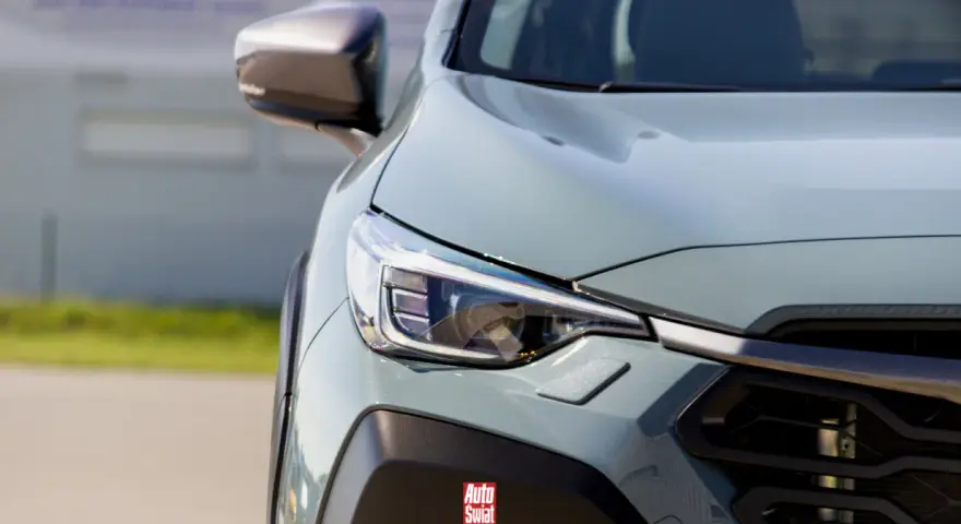 Szary, nowoczesny SUV z reflektorem LED. Logo "Auto Świat" na zderzaku sugeruje, że to auto top marki.