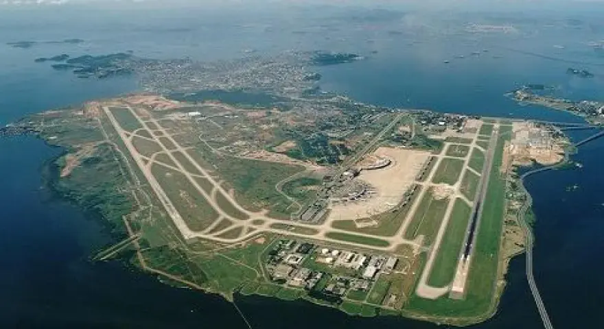 Lotnisko Rio de Janeiro z lotu ptaka, z pasami startowymi i terminalem, otoczone wodą i zielenią.