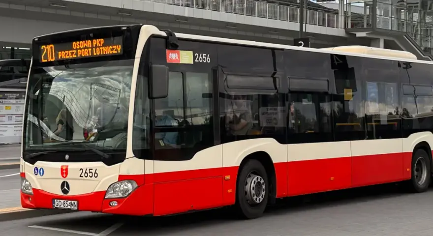 Autobus linii 210 z napisem "OSOWA PKP PRZEZ PORT LOTNICZY" na wyświetlaczu, gotowy do podróży z Gdańska Głównego na lotnisko.
