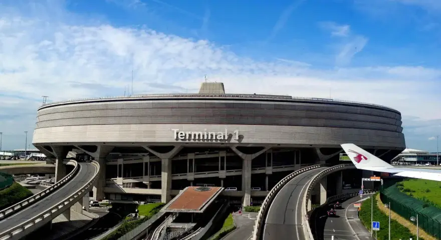 Terminal 1 na lotnisku w Paryżu, najbliżej centrum, z charakterystyczną architekturą i drogami dojazdowymi.
