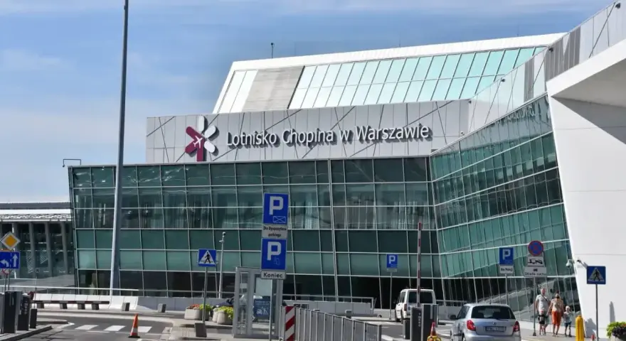 Nowoczesny budynek Lotniska Chopina w Warszawie. Droga prowadzi do terminalu, gdzie zaczyna się podróż z Warszawy Centralnej do lotniska Chopina.