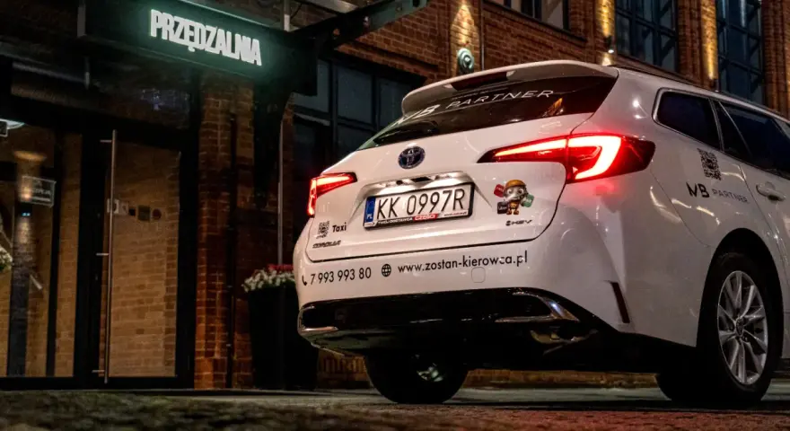 Białe auto z naklejką Bolt i Uber, gotowe do pracy. Kierowca liczy na dobre zarobki.