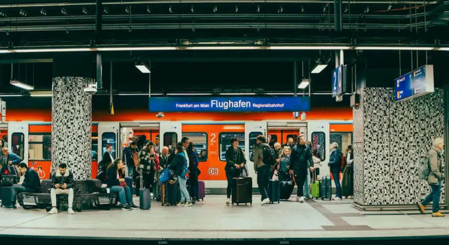 Pasażerowie z bagażami czekają na pociąg na peronie lotniska Frankfurt am Main Flughafen Regionalbahnhof.
