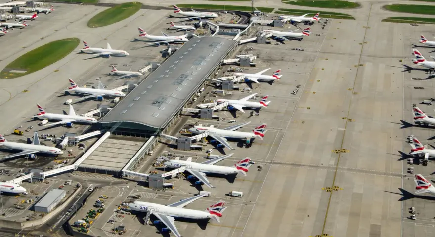 Lotnisko Heathrow tętni życiem, z wieloma samolotami British Airways czekającymi na pasażerów.