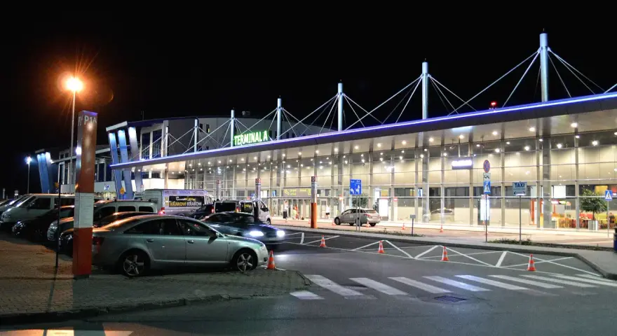 Nocne lotnisko Kraków-Balice, Terminal A. Samochody czekają na pasażerów, a światła tworzą niepowtarzalny klimat.